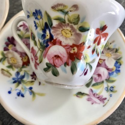 Paire de tasses en porcelaine de Paris à décor de fleurs multicolores